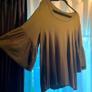 Olive green knit top with ruffle sleeve trim.
